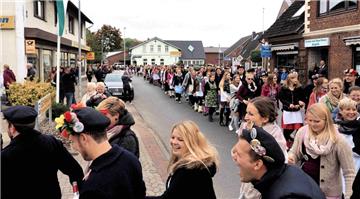 Eine bunte Menschenmenge schlängelt sich durch den kleinen Ort.
