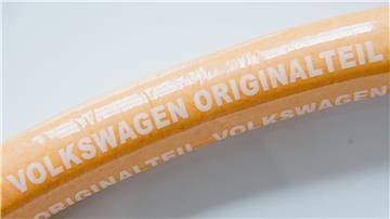 Eine Currywurst mit Aufschrift „Volkswagen Originalteil“ liegt auf einem Teller.