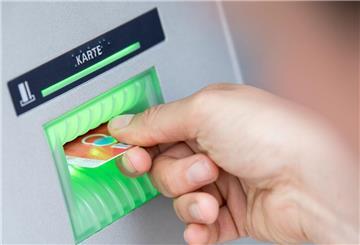 Eine Person steckt ihre EC-Karte in einen Geldautomaten.