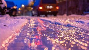 Eine dünne Eisschicht überzieht am frühen Morgen eine Straße.
