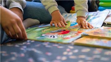 Eine Erzieherin liest in einer Kita Kindern vor.