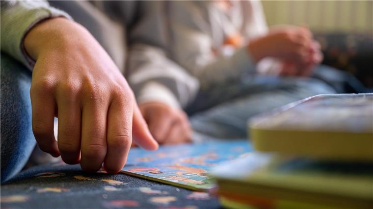 Städtetag: Mehr Geld für Finanzierung von Kita-Personal Eine Erzieherin liest in einer Kita Kindern vor.