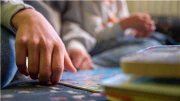 Eine Erzieherin liest in einer Kita Kindern vor.