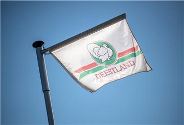 Eine Fahne mit dem Logo vom Schlachthof Geestland Putenspezialitäten weht im Wind.