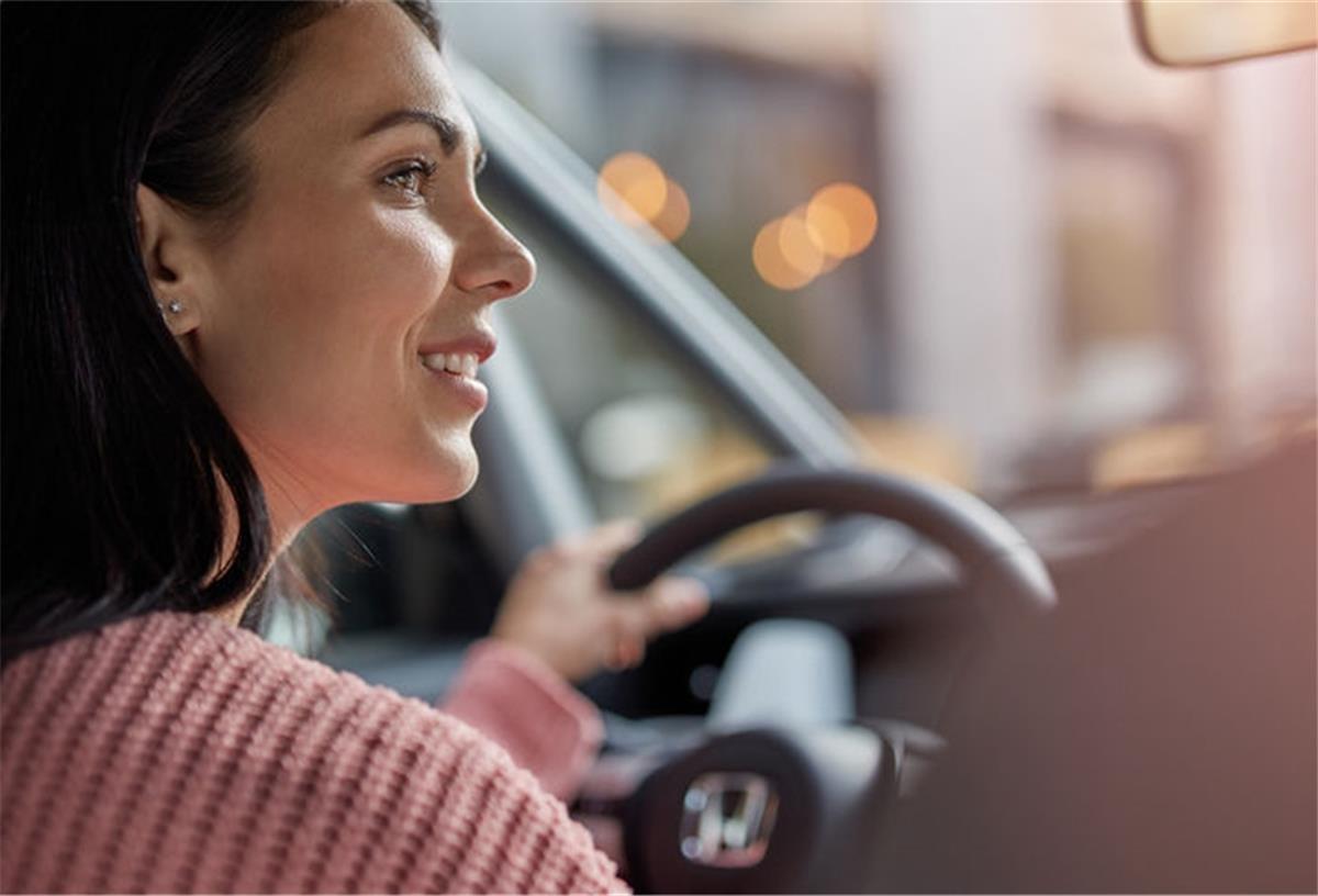 Modern und dynamisch fahren? Ja, mit neuester Hybridtechnik! Frau fährt Honda Jazz