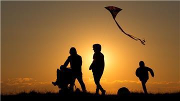 Eine Familie geht bei Sonnenuntergang über einen Weg.