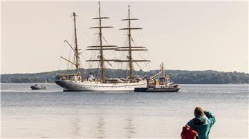 Eine Frau beobachtet vom Ufer aus die „Gorch Fock“ in der Innenförde.