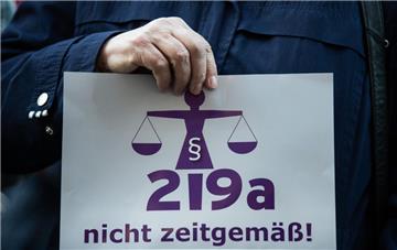 Eine Frau hält bei einer Demonstration einen Zettel mit der Aufschrift "219a nicht zeitgemäß!".