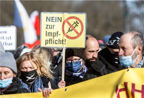 Eine Frau hält ein Schild mit der Aufschrift „Nein zur Impfpflicht". Mitarbeiter im Pflege- und Gesundheitsbereich sind seit März zu einer Coronaimpfung verpflichtet.