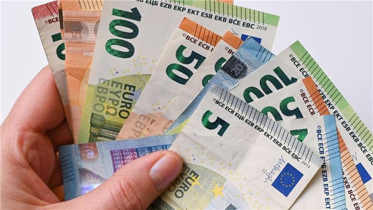 Eine Frau hält Geldscheine in der Hand.