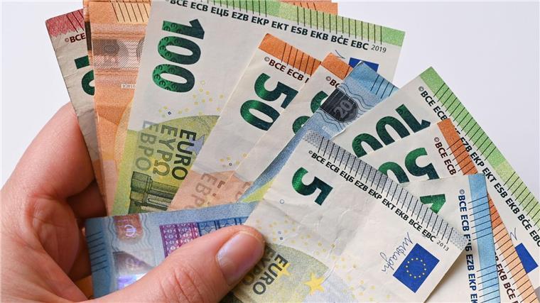 Gewerkschaften stellen Tarifforderungen für die Länder auf Eine Frau hält Geldscheine in der Hand.