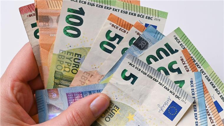 Eine Frau hält Geldscheine in der Hand.