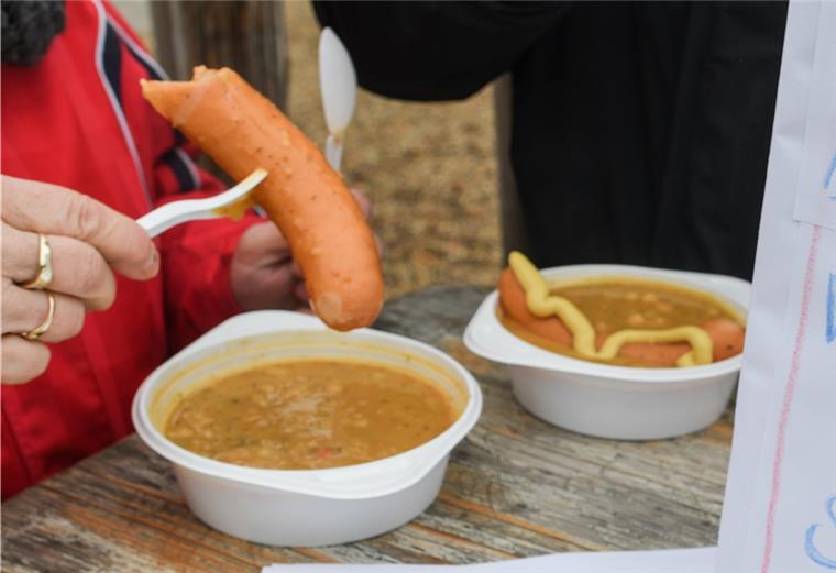 Eine Frau isst Erbsensuppe.
