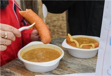 Eine Frau isst Erbsensuppe.