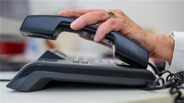 Festnetzstörung im Großraum Hamburg ist behoben Eine Frau nimmt einen Telefonhörer in die Hand.