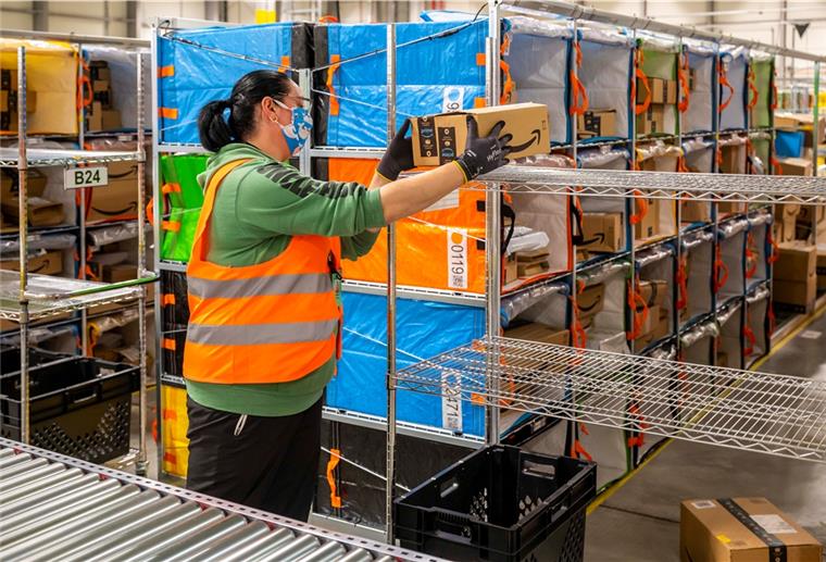So viele Pakete packt Amazon in Bremerhaven Eine Frau packt Pakete im Verteilzentrum von Amazon in Bremerhaven.