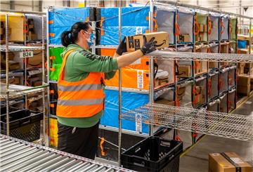 Eine Frau packt Pakete im Verteilzentrum von Amazon in Bremerhaven.
