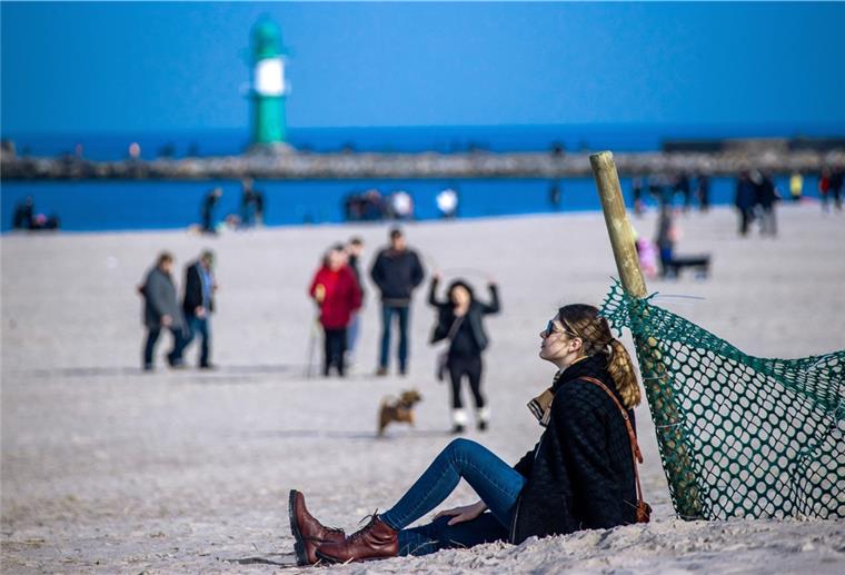 Drastischer Einbruch beim Tourismus 2020 Eine Frau sitzt am Strand von Warnemünde und sonnt sich.