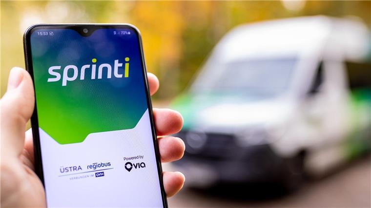 Kleinbus per App: Sprinti wird ausgezeichnet Eine Hand hält ein Smartphone auf dessen Bildschirm die Startmaske der App „Sprinti“, einem Projekt der Üstra Hannoversche Verkehrsbetriebe und Regiobus, zu sehen ist.