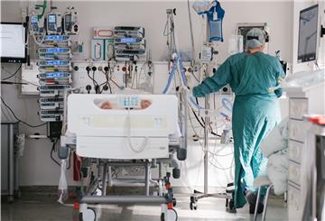 Eine Intensivpflegerin versorgt auf der Intensivstation einen an Covid-19 erkrankten Patienten. Die Corona-Infektionszahlen steigen - und auch auf den Intensivstationen müssen wieder mehr Patienten behandelt werden.