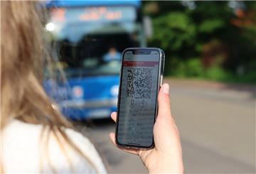 Eine junge Frau blickt auf ein 9-Euro-Ticket auf einem Smartphone. Seit dem 1. Juni gilt das Rabattticket in Bus und Bahn.