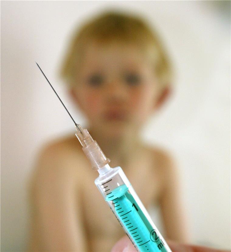 Eine Kinderärztin hält in ihrer Praxis eine Spritze mit einem Impfstoff.