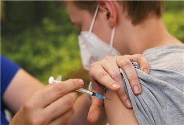 Eine Kinderärztin impft einen Jungen mit Corona-Impfstoff.
