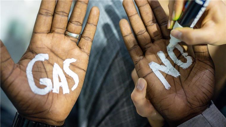 Eine Klimaaktivistin der „Fridays for Future“-Bewegung schreibt „No Gas“ auf Handflächen.