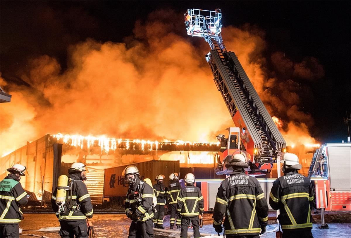 Hamburg: Lagerhalle steht in Flammen - Großeinsatz für Feuerwehr Feuerwehrleute löschen im Stadtteil Wilhelmsburg ein Großbrand. Eine Lagerhalle in einem Gewerbegebiet steht seit dem Morgen im Vollbrand.