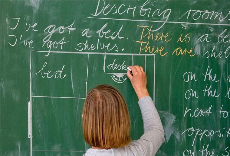 Landesverband der Gewerkschaft GEW empört über Vorschläge gegen Lehrkräftemangel Eine Lehrerin schreibt an die Tafel.