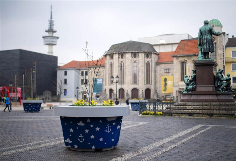 Ein Kübel mit Hafensymbolen darauf ist auf einem öffentlichen Platz zu sehen. 