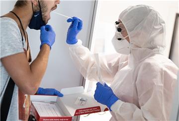 Eine Mitarbeiterin testet bei einem Medientermin im neuen, kommerziellen Covid-19-Testzentrum am Flughafen Hamburg einen Urlauber nach seiner Rückkehr.