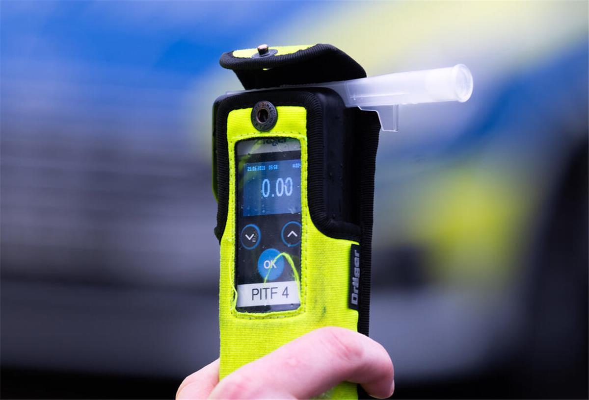 Kein Alkohol bis 25? Neue Regel für junge Fahrer in Planung Ein Polizeibeamter hält während einer Verkehrskontrolle ein Messgerät, das den Alkoholwert von Null Promille anzeigt.