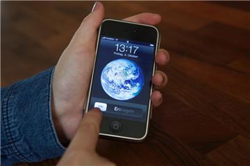 Eine Nutzerin entsperrt ein iPhone 2G mit der Schiebe-Geste, die Apple patentgeschützt hat. Das Patent spielt in der juristischen Auseinandersetzung zwischen Apple und Samsung eine wichtige Rolle.