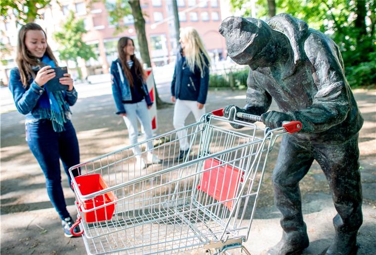 Bremens neuer Bronzemann sorgt für Rätsel Eine Passantin fotografiert in Bremen eine Bronzefigur, die mit einem Einkaufswagen in den Händen in den Wallanlagen im Zentrum der Stadt steht. Woher die Figur kommt und wofür sie steht, ist völlig unklar.