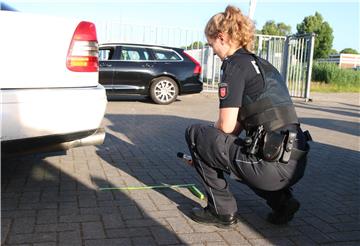 Eine Polizisten überprüft die Vorgaben an einem getuntem Auto.