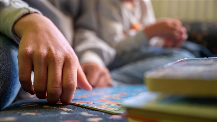 Tag der gewaltfreien Erziehung Eine Praktikantin liest in einer Kita Kindern vor..