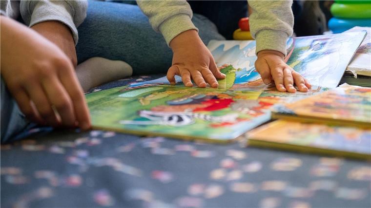 Volksinitiative für kleinere Kita-Gruppen hat wenig Aussicht Eine Praktikantin liest in einer Kita Kindern vor.