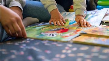Eine Praktikantin liest in einer Kita Kindern vor.