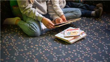Eine Praktikantin liest in einer Kita Kindern vor.
