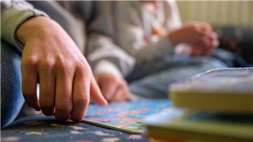 Eine Praktikantin liest in einer Kita Kindern vor.