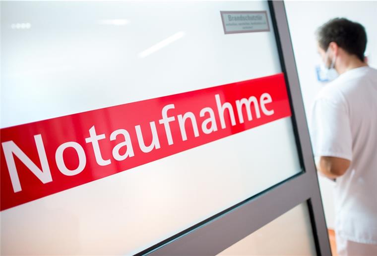 Ein Krankenpfleger in einem Krankenhaus geht durch eine Glastür mit der Aufschrift "Notaufnahme". 
