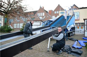 Eine Reifen-Rodelbahn bereichert in diesem Jahr den Weihnachtsmarkt. Björn Eggers (vorne) und Benjamin Feicht bringen beim Aufbau am Freitag eine Stütze unter dem Rutschkanal an. 