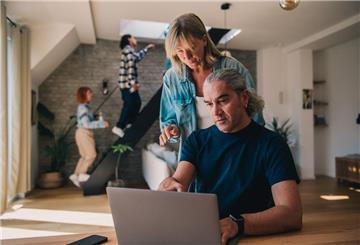 Ein Mann und eine Frau blicken auf einen Laptop. Eine Risikolebensversicherung schützt Hinterbliebene vor finanziellen Einbußen. Entscheidend sind Laufzeit und Versicherungssumme – angepasst an die Familiensituation.