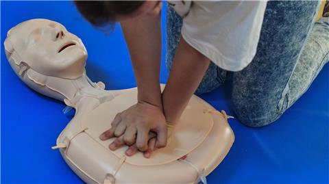 Eine Schülerin der Friedensgrundschule übt die Wiederbelebung an einem Dummy.