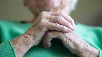 Eine Seniorin faltet ihre Hände.