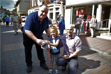 Eine Spende fürs Feuerwerk ist Ehrensache für Carlotta und ihren Papa Andreas Gerdes (rechts). Ein kräftiger Druck von der kleinen Kinderhand, und schon klappert es lustig in Micheal Leydas Sammelbüchse.
