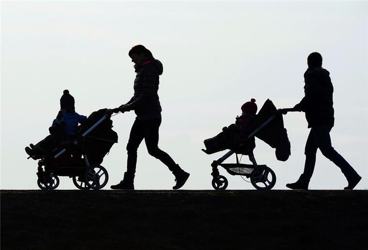 Eltern zwischen Zukunftsangst und Überforderung – Was Eltern am meisten belastet Zwei Mütter schieben Kinderwagen eine Landstraße entlang.