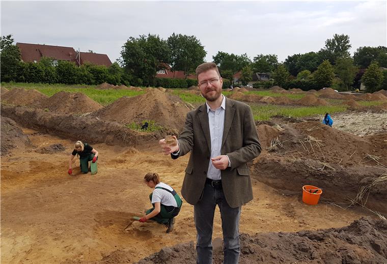 Alte Siedlung im Bülstedter Neubaugebiet Eine Tonscherbe könnte einen Hinweis darauf geben, wann hier Menschen gesiedelt haben. Kreisarchäologe Dr. Stefan Hesse präsentiert das frisch freigelegte Fundstück an der Grabungsstätte am Rande Bülstedts.
