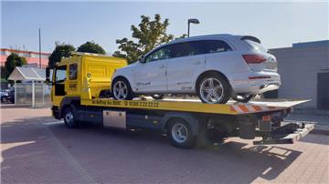 Ein Sportgeländewagen steht auf der Ladefläche eines Abschleppwagens
